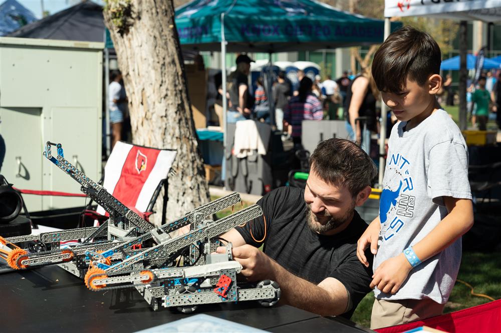 An image of a student and adult from Tarwater working with a robot.